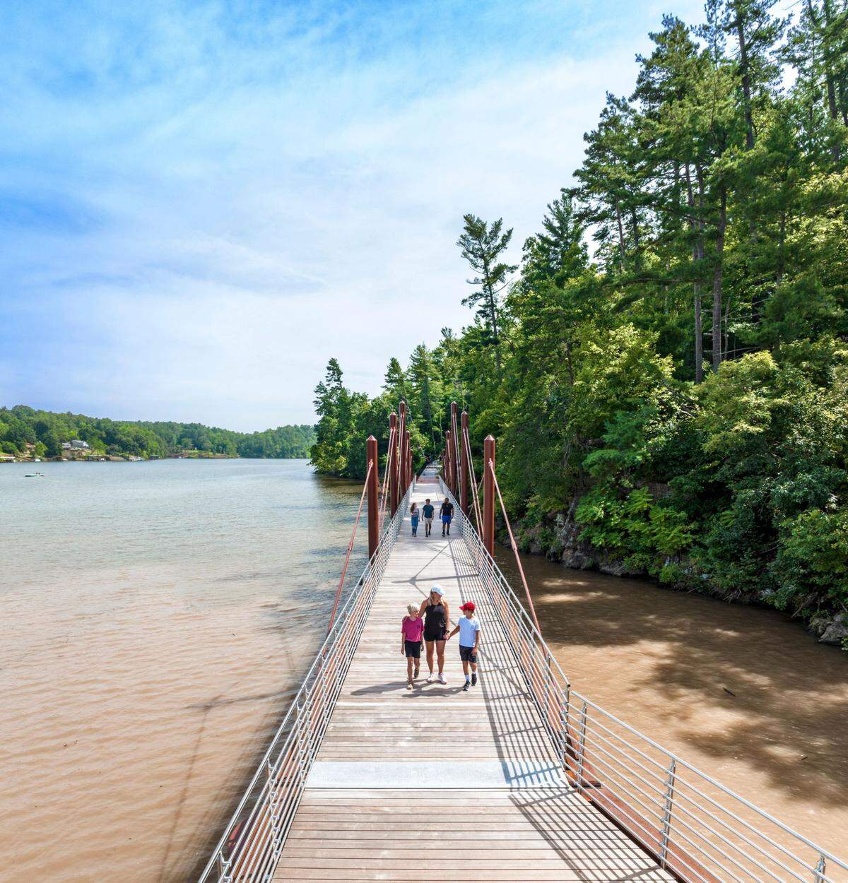 Families walking across a bridge along the Hickory Riverwalk. 