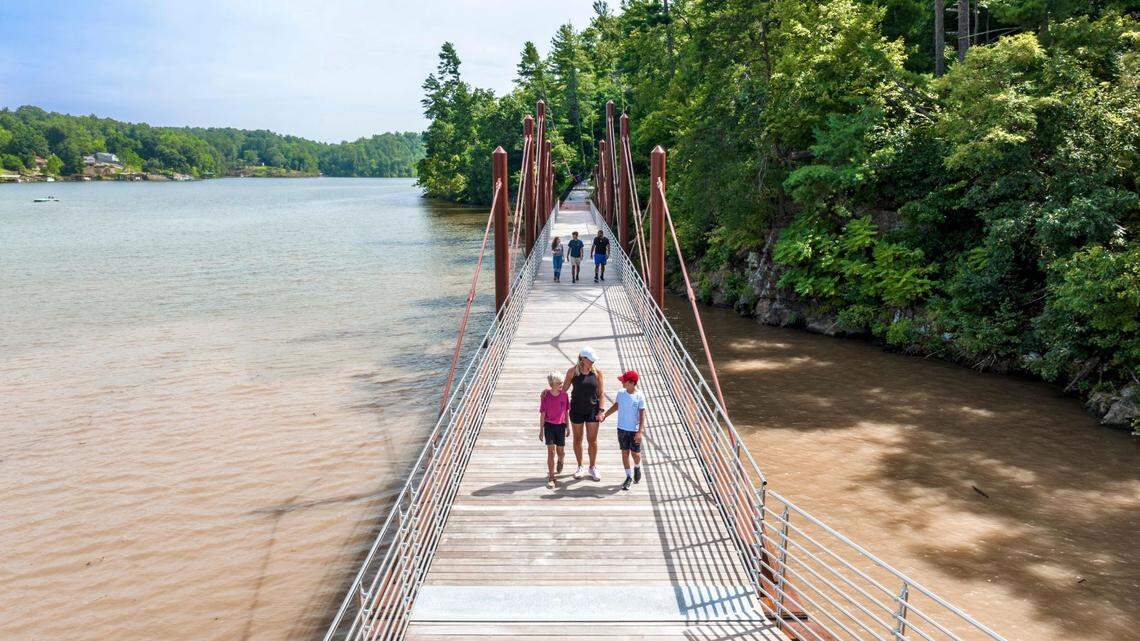 Families walking across a bridge along the Hickory Riverwalk.