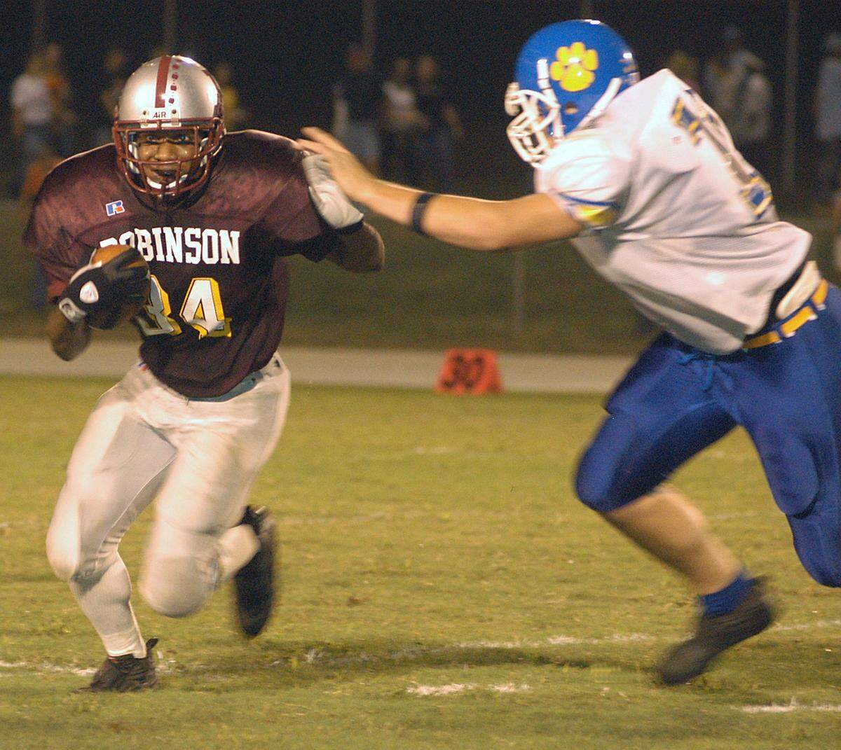 Jay M. Robinson running back Princeton Williford (left) hand checks Mt. Pleasant's Daniel Yow before making a gain.