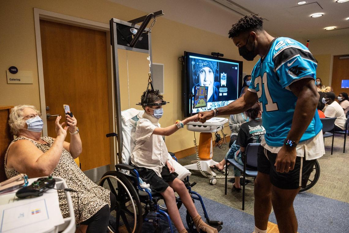 Carolina Panthers Jeremy Chinn, right, greets Zac Barnett, 14, at Atrium Levine Children’s Hospital in Charlotte, N.C., on Monday, July 18, 2022. Christian McCaffrey and Christian McCaffrey Foundation commemorated ‘The Logan Project,’ presenting the first nine gaming consoles for pediatric patients to Atrium Health Levine Children’s Hospital and delivering on the dream of Logan Hale, who lost his battle with childhood cancer in late 2021.