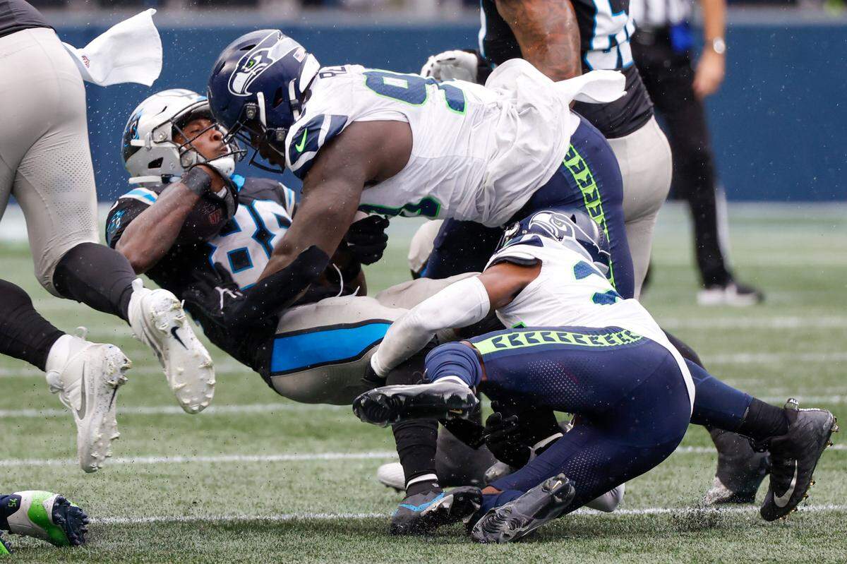Sep 24, 2023; Seattle, Washington, USA; Seattle Seahawks defensive tackle Jarran Reed (90) assists cornerback Artie Burns (23) on a tackle of Carolina Panthers wide receiver Terrace Marshall Jr. (88) during the fourth quarter at Lumen Field. Mandatory Credit: Joe Nicholson-USA TODAY Sports