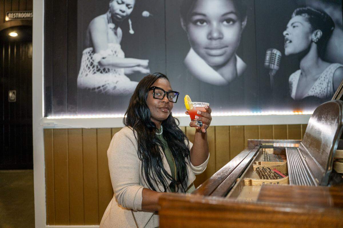 Patrice Jennings, owner of Harlem Nights Restaurant, paid homage to her mother by adding her to likeness to the mural behind her.