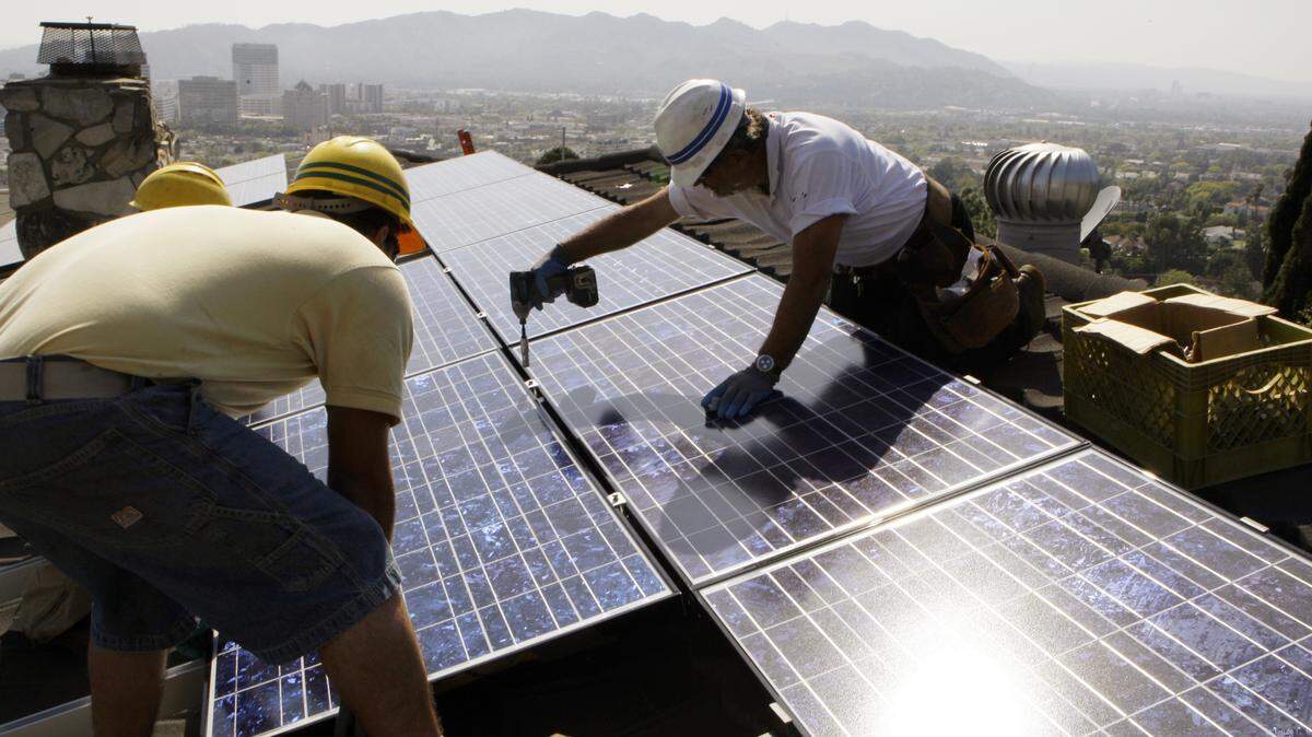 FILE - In this March 23, 2010, file photo, installers from California Green Design install solar electrical panels on the roof of a home in Glendale, Calif. The Obama administration is boosting the development of solar and wind energy on public lands. A final rule announced by the Interior Department on Thursday, Nov. 10, 2016, would create a new leasing program on public lands and encourage development in areas where it would have fewer effects on the environment.  (AP Photo/Reed Saxon, File)