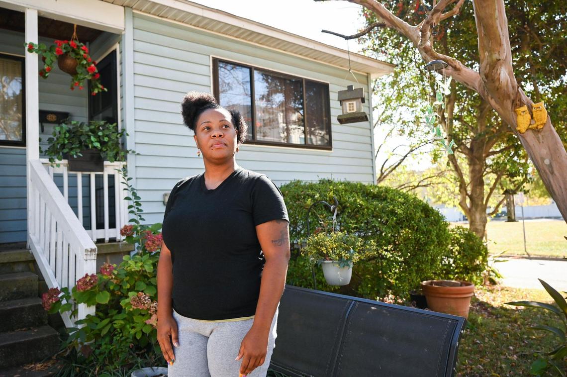 Rachel Little stands outside her mother’s home, which was built by Habitat for Humanity. On her street, all but one house built by Habitat is still occupied by the original owner.