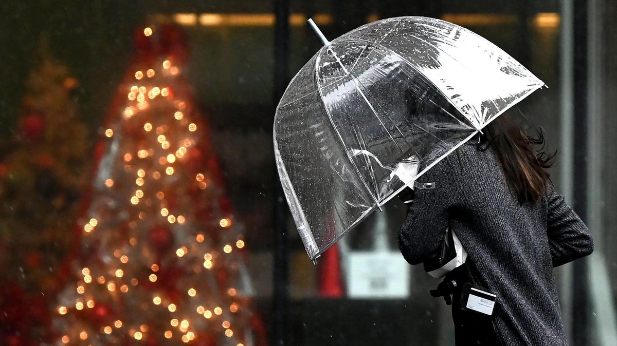 A pedestrian braces themselves against the rain and wind as they walk along South Tryon St. in Charlotte, NC on Tuesday, January 9, 2024.
