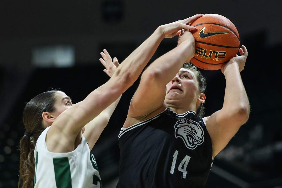 Davidson’s Maddie Plank, left, shoots as UNC-Charlotte’s Jacee Busick (20) defends during the game at Halton Arena on Thursday, December 21, 2023. Davidson’s victory is their ninth win in a row and the best start to a season in the program’s history.