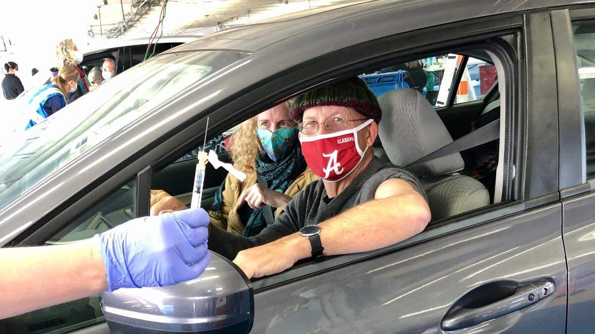 Observer reporter Michael Gordon, with wife Jennifer Halls, prepares to receive his COVID-19 vaccine in the garage at Charlotte Motor Speedway in Concord, NC, on Friday, January 22, 2021.