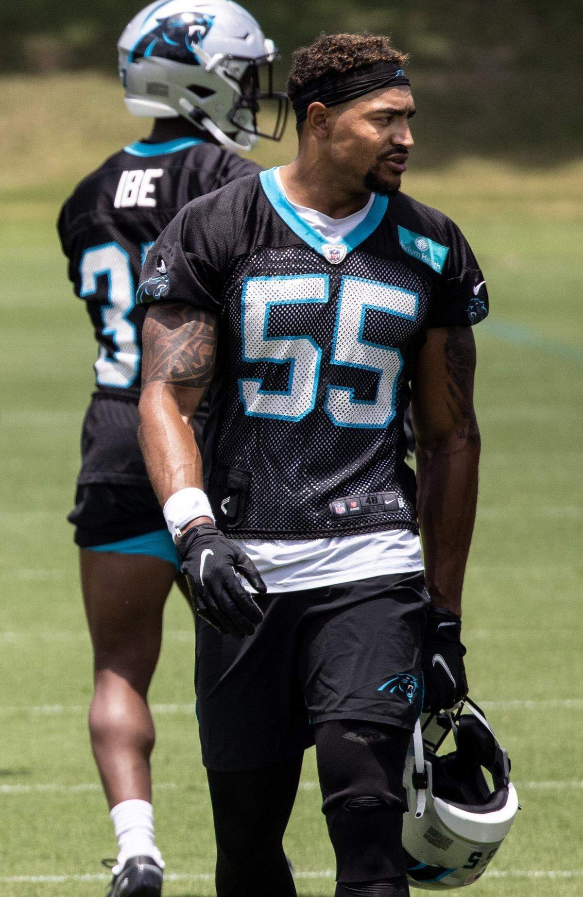 Carolina Panthers defender Christian Miller walks with his helmet in his hand during practice in Charlotte, N.C., on Wednesday, June 16, 2021.