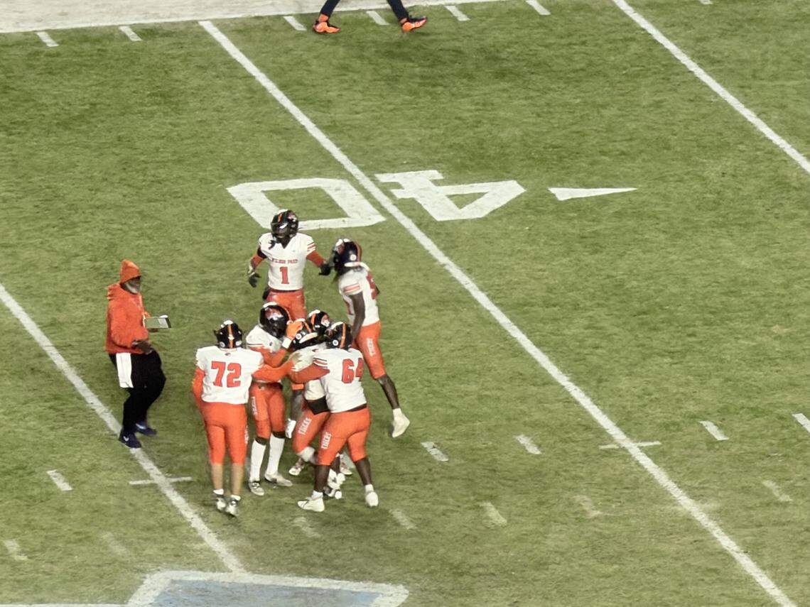 Wilson Prep players surround kicker Ethan Nelson, who made a championship-winning kick in the final seconds against Robbinsville to win the 1A state title.