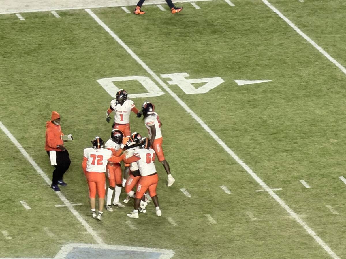 Wilson Prep players surround kicker Ethan Nelson, who made a championship-winning kick in the final seconds against Robbinsville to win the 1A state title.