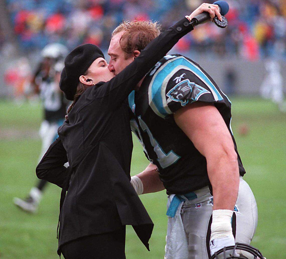 Panthers linebacker Kevin Greene gives his wife Tara a kiss after she sang the national anthem before a game Sunday at Ericsson Stadium in 1996.