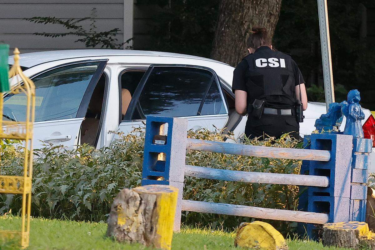 A crime scene investigator approaches a white sedan believed to be stolen on Onyx Street in Charlotte on Thursday, Sept. 15, 2022. Three Charlotte-Mecklenburg police officers fired their weapons at an armed suspect, according to a deputy chief at the scene.