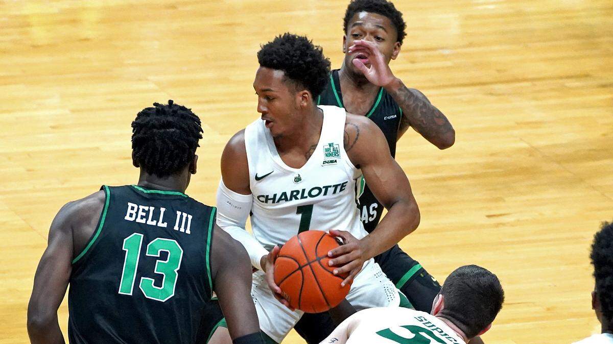 Charlotte 49ers guard Jahmir Young (1) recovers a loose ball as the North Texas Mean Green defense collapses around him.