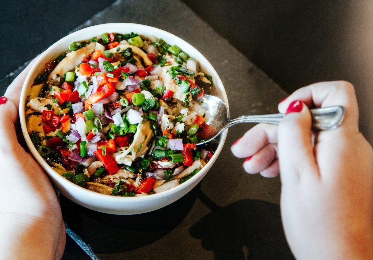 Viva Chicken’s Sopa De Pollo with homemade chicken broth, rotisserie chicken, cilantro rice, green onions, red onions, red peppers and cilantro.
