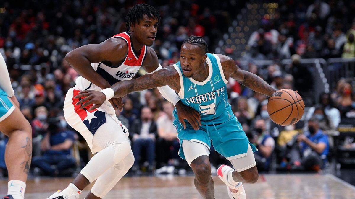 Charlotte Hornets guard Terry Rozier (3) dribbles the ball as Washington Wizards guard Aaron Holiday defends during the second half of an NBA basketball game Monday, Nov. 22, 2021, in Washington. (AP Photo/Nick Wass)
