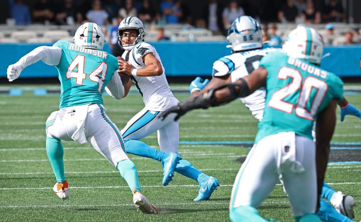 Carolina Panthers quarterback Bryce Young, center, scrambles in the pocket during action against the Miami Dolphins on Sunday, October 5, 2025 at Bank of America Stadium in Charlotte, NC. The Panthers defeated the Dolphins 27-24.  