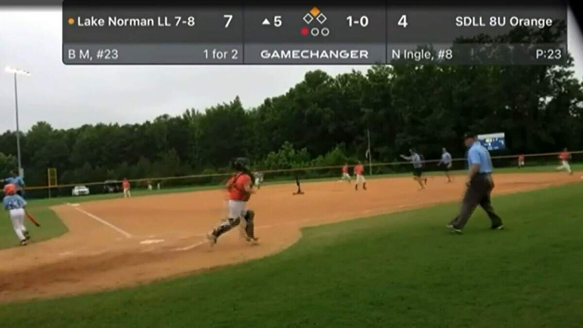 In this screen capture from video provided to WSOC, Lake Norman and South Durham players and coaches and umpires run for safety after gunfire erupted near a baseball tournament in Wilson, N.C., on Sunday, July 10, 2022.