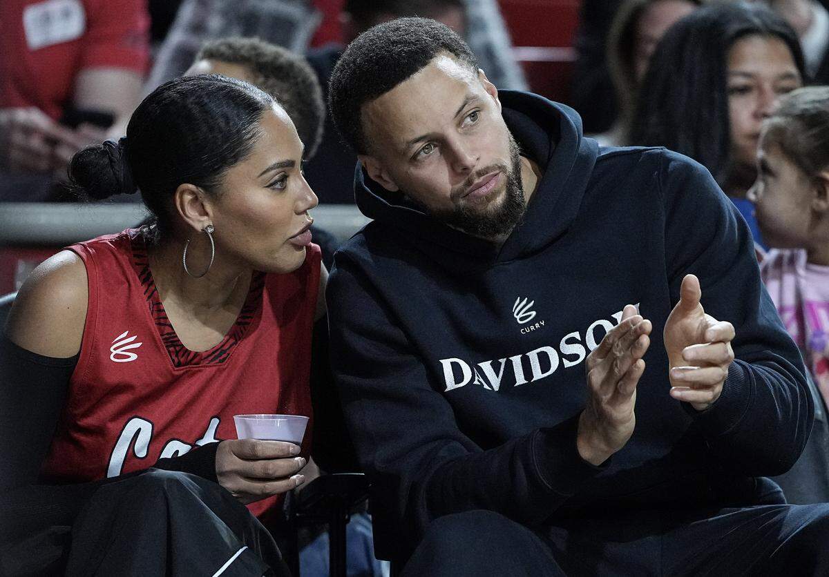 Golden State Warrior guard and Davidson alumni Stephen Curry, right, sits next to wife Ayesha Curry during the first half of an NCAA college basketball game between Davidson and Duquesne, Tuesday, Dec. 30, 2025, in Davidson, N.C.