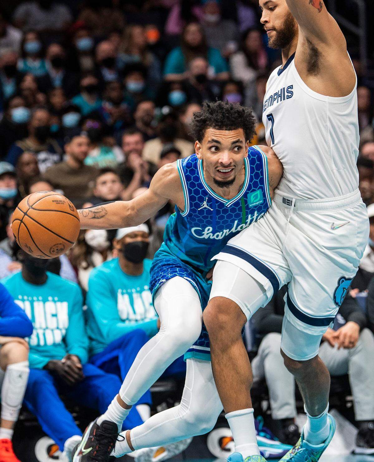 Hornets guard James Bouknight, left, leans into Grizzlies forward Santi Aldama as he drives the ball during the game at Spectrum Center on Saturday, February 12, 2022 in Charlotte, NC.