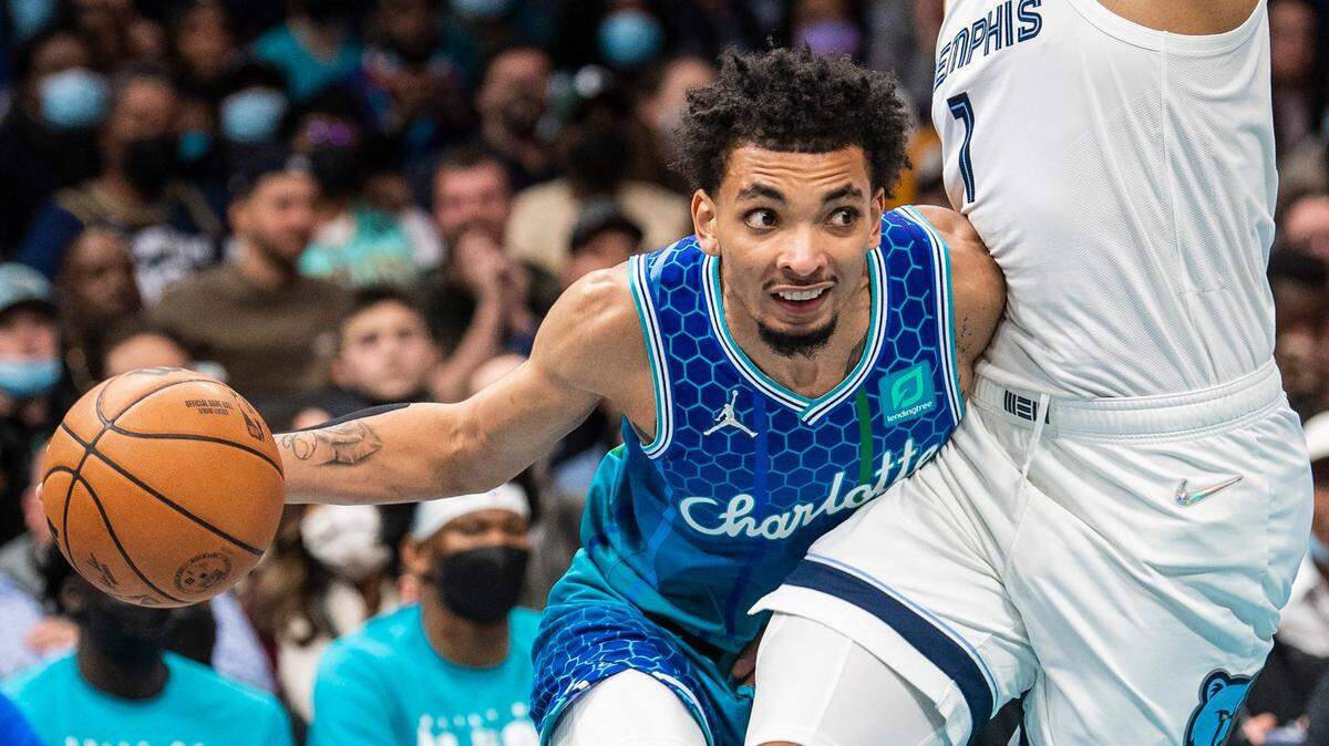 Hornets guard James Bouknight, left, leans into Grizzlies forward Santi Aldama as he drives the ball during the game at Spectrum Center on Saturday, February 12, 2022 in Charlotte, NC.