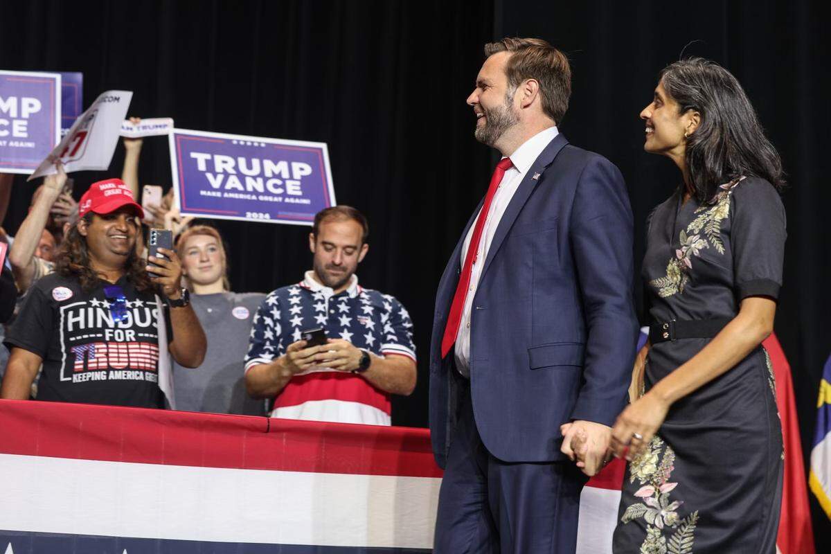 Senator JD Vance, the GOP vice presidential nominee, and his wife, Usha, walk on the stage before Vance speaks to supporters during a rally at Dale F. Halton Theater on the campus of CPCC in Charlotte, NC on Monday, September 23, 2024.