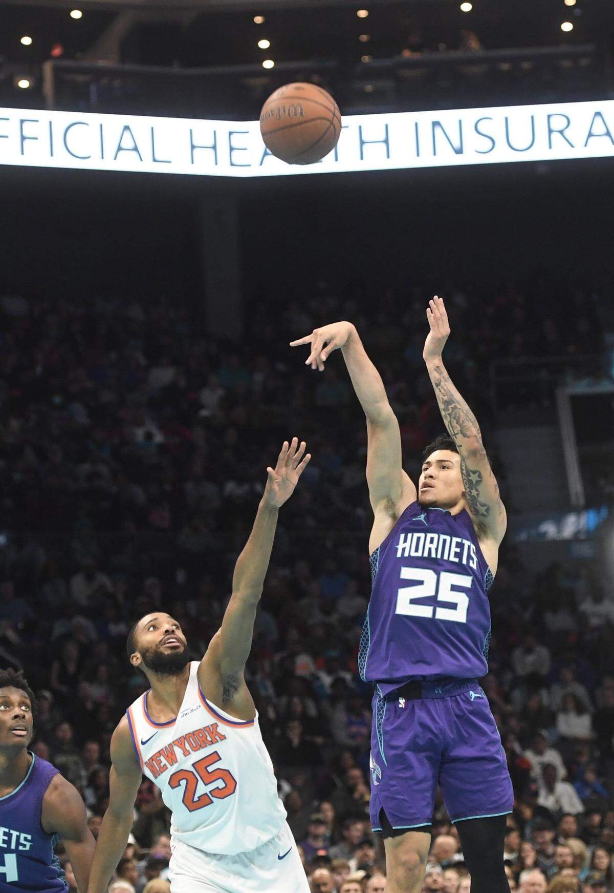 Charlotte Hornets guard KJ Simpson (25) shoots past New York Knicks forward Mikal Bridges (25) during the second half at the Spectrum Center.