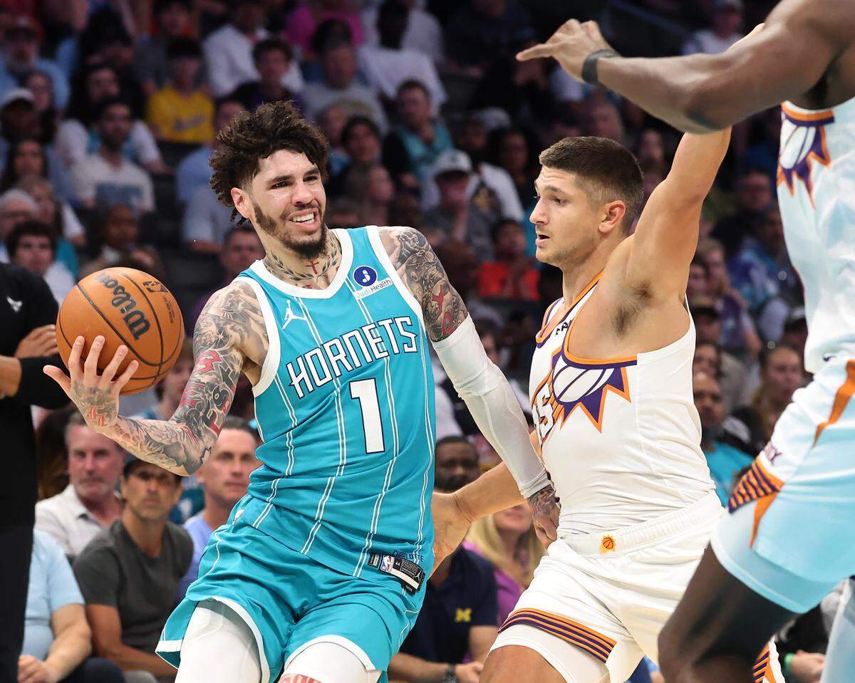 Charlotte Hornets guard LaMelo Ball fights his way around Phoenix Suns guard Grayson Allen during action at Spectrum Center in Charlotte, North Carolina, on Thursday, April 2, 2026.