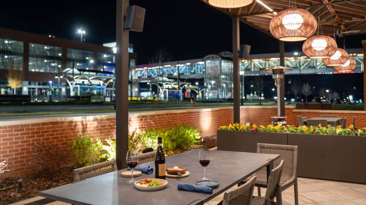 The patio at Golden Owl Tavern overlooks the LYNX Blue Line’s JW Clay Blvd. Station. The restaurant’s side patio (not shown) has fire pits with chairs surrounding.