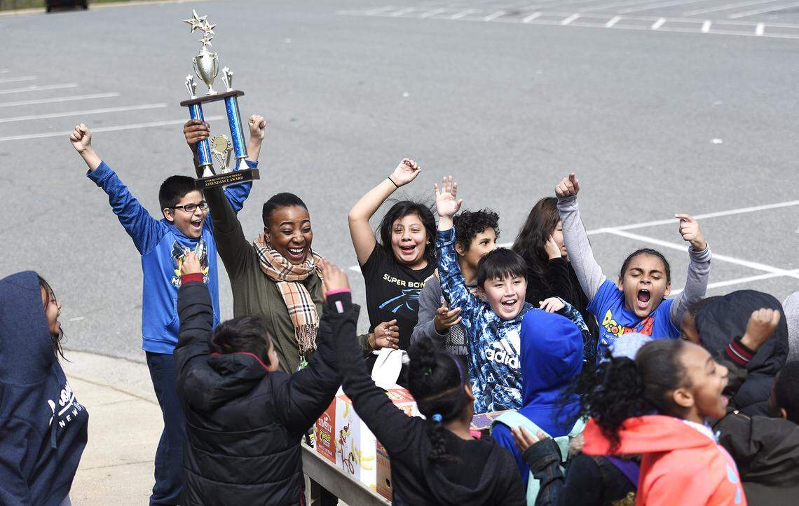 Carla Gaymon, Communities in Schools site coordinator at Allenbrook Elementary, awards a traveling trophy to the class with the best monthly attendance.  For the fourth month in a row Katie Magee's fifth-graders won.