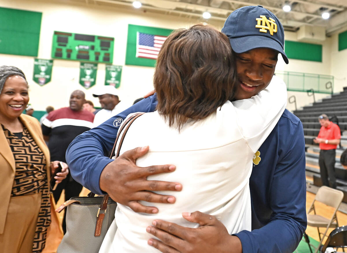 Myers Park High’s Rodney Dunham, right, receives a big hug following his announcement that he will be attending Notre Dame. Dunham a Top 10 national football recruit had narrowed down his choices to Duke, South Carolina, Georgia, Tennessee and Notre Dame.