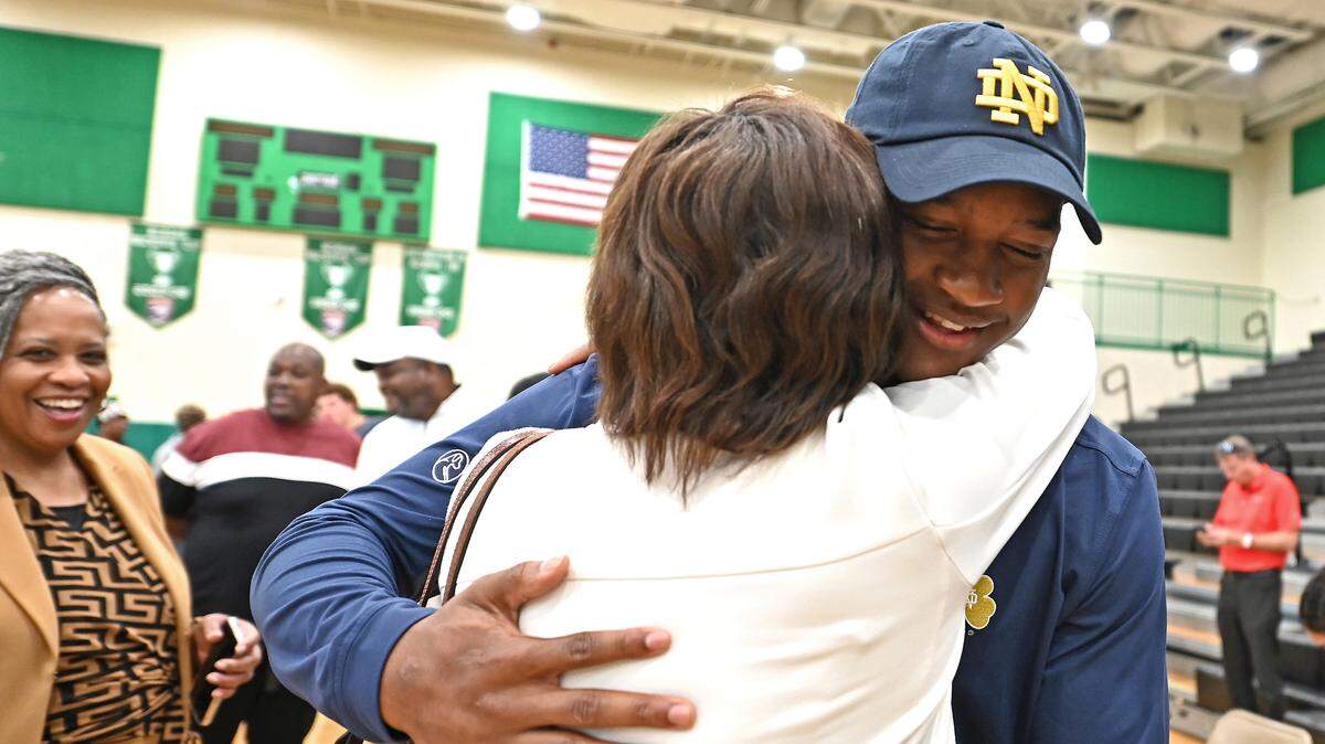 Myers Park High’s Rodney Dunham, right, receives a big hug following his announcement that he will be attending Notre Dame. Dunham a Top 10 national football recruit had narrowed down his choices to Duke, South Carolina, Georgia, Tennessee and Notre Dame.