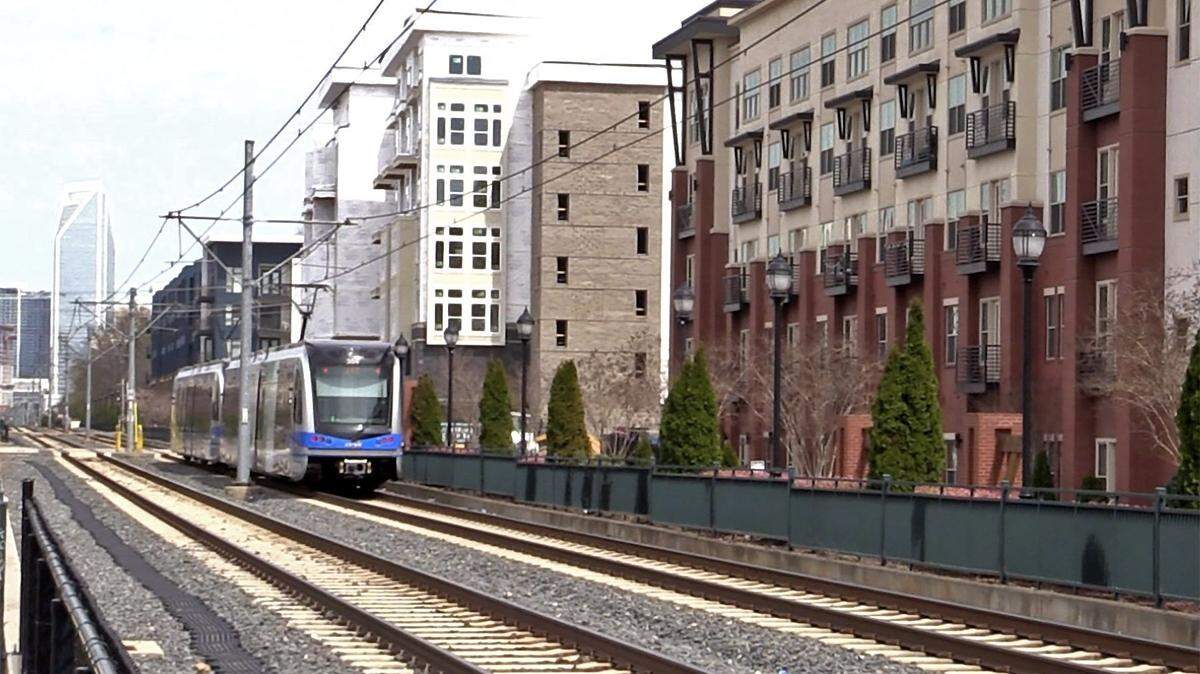 A light rail train passes through New Bern Street at Rail Crossing Lane station heading to uptown Charlotte.