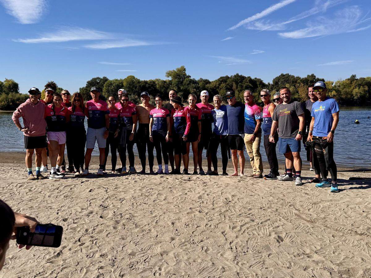Théoden Janes, at far right, photographed with teammates before a pre-race swim in the American River in Sacramento, Calif., on Oct. 17.