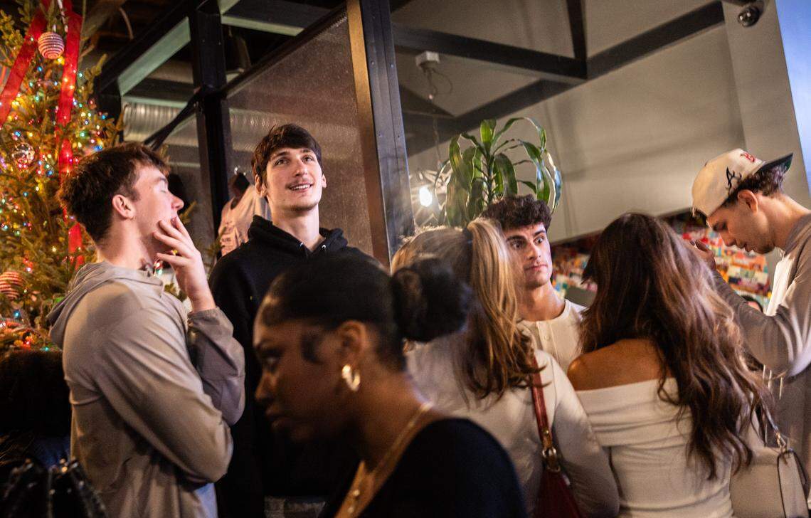 UNC Charlotte basketball player, Anton Bonke, in the black shirt, towers over a crowd standing at 7-foot-2-inches during the Tall Tour event at Brewers At 4001 Yancey in Charlotte, N.C., on Saturday, December 6, 2025.