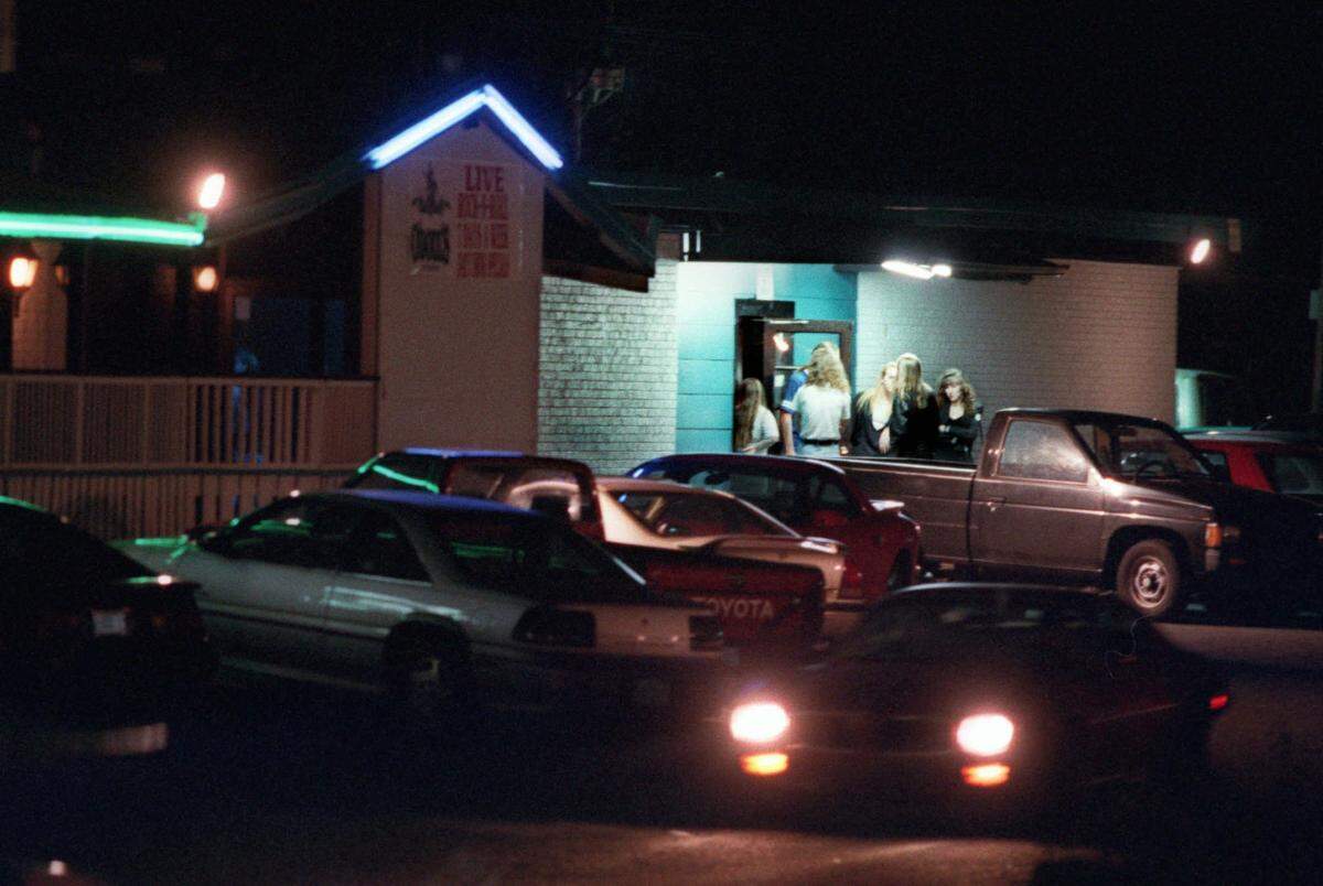 Patrons gather around the door of Jeremiah’s near closing time on a Friday night in December 1995.