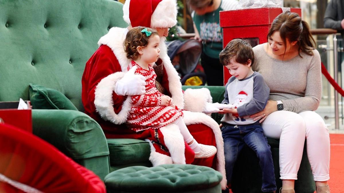 Cecilia Veiga, Leo Veiga and Ashley Veiga get seated next to Santa Claus during the Caring Santa event at the SouthPark Mall in Charlotte, NC on Sunday, December 4, 2022. The event is for children with disabilities and are adversely affected by high sensory events such as a loud, busy mall. The Caring Santa event was hosted before regular mall hours.
