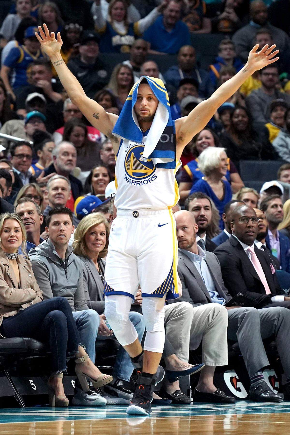 Golden State Warriors guard Stephen Curry raises his arms in celebration of teammate Kevin Durant’s basket during the Warriors’ 121-110 win over the Charlotte Hornets Monday. Curry had an off night shooting, scoring 16 points while making 5-of-18 shots from the field.