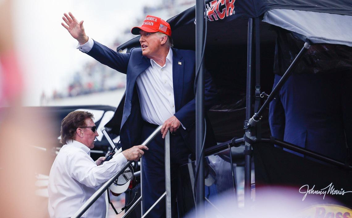 Former President Donald Trump raises a fist to chanting supporters as he, and team owner Richard Childress, enter the bay for #3 driver Austin Dillon during the Coca-Cola 600 at Charlotte Motor Speedway in Concord on Sunday, May 26, 2024.