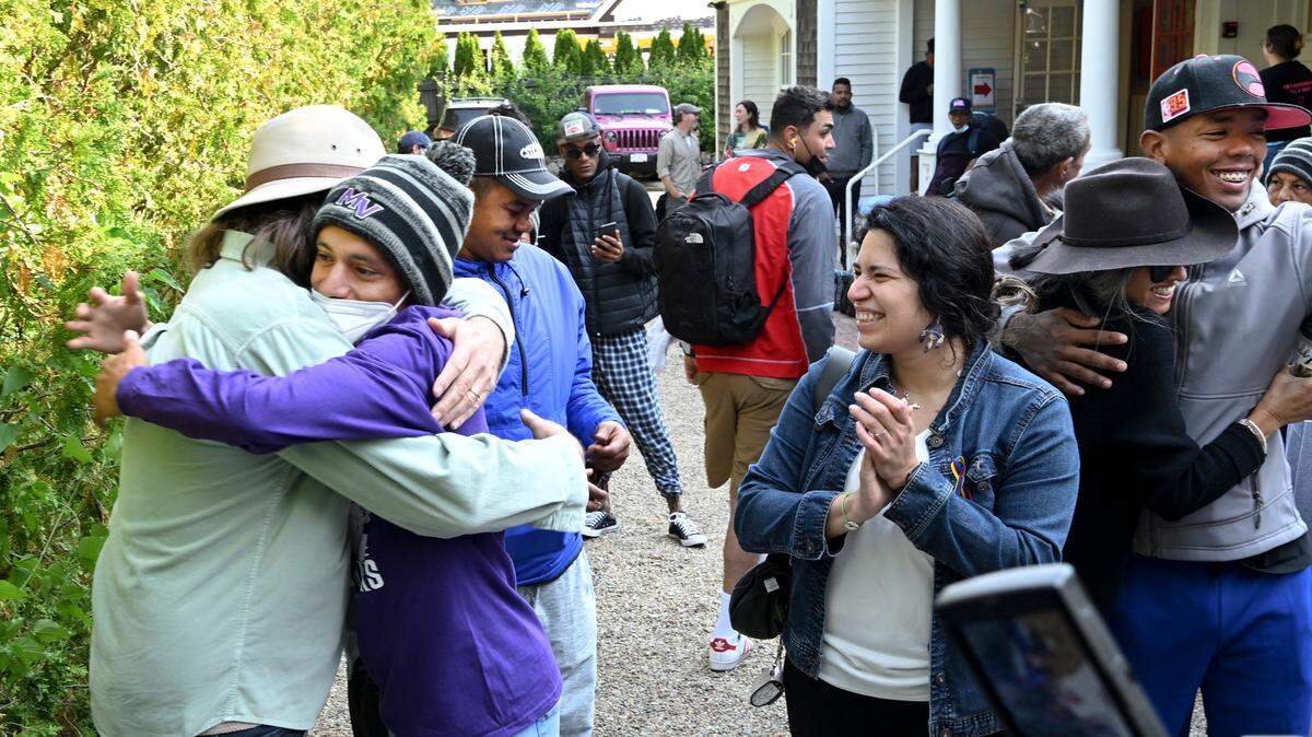 Carlos Munoz reaches out to hug Larkin Stallings of Vineyard Haven, Mass. before leaving Martha’s Vineyard on Sept 16, 2022. Munoz was among 50 migrants that Florida Gov. Ron DeSantis flew unannounced to the upscale island enclave. When two planeloads of migrants arrived without notice on Sept. 14, local residents, churches and agencies rallied to provide them food and shelter.