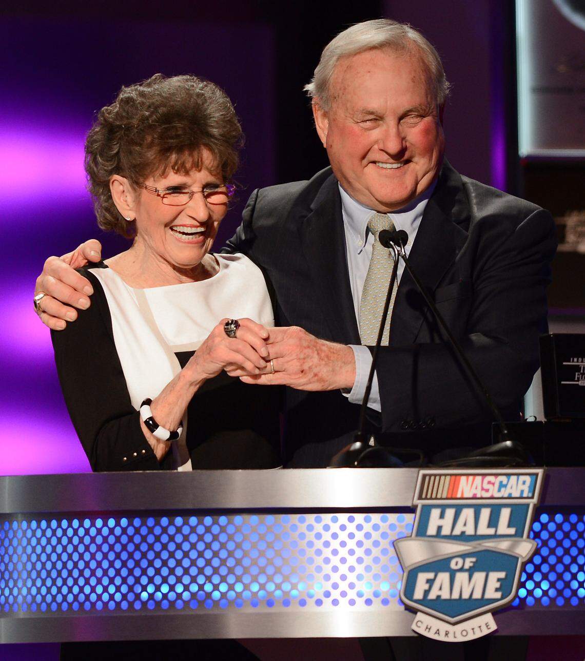 (L-R) Francis Flock is embraced by Humpy Wheeler after he presented her with her husband, Tim Flock's NASCAR Hall of Fame ring in 2014.
