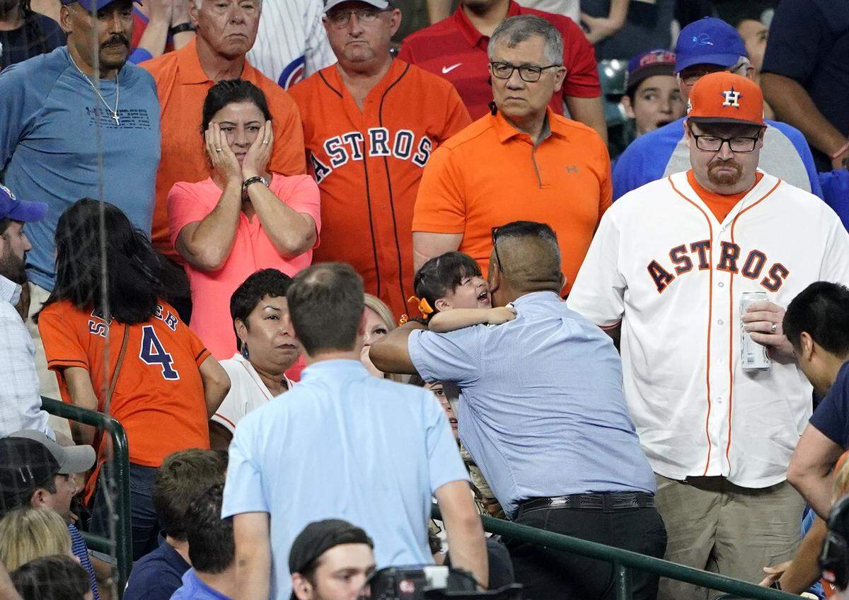 A young child is carried from the stands after being injured by a foul ball off the bat of Chicago Cubs’ Albert Almora Jr. during the fourth inning of a baseball game against the Houston Astros in Houston on May 29, four days after Milledge was struck.