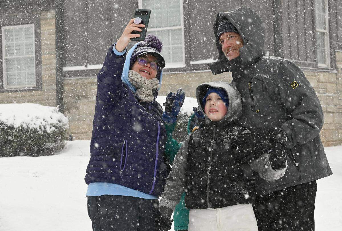 Before heading off to sled, Kelly McAuliffe, left, takes a photograph with her family Connor, right, Jude, hidden in back and husband Jason McAuliffe in Charlotte, NC on Saturday, January 31, 2026.