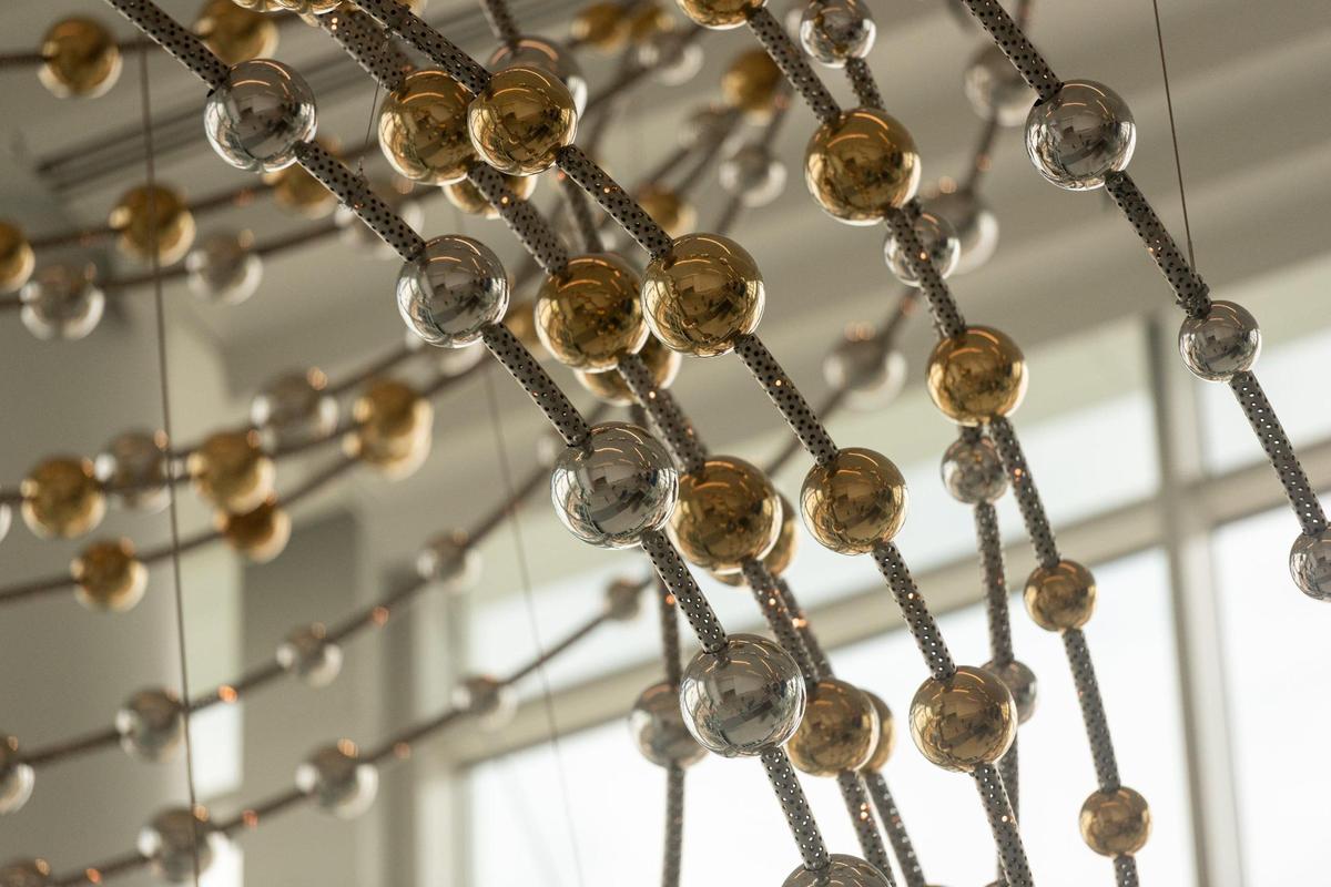 Meridian, a suspended sculpture by Danielle Roney, hangs in the west portion of the Terminal Lobby Expansion at the Charlotte Douglas International Airport on Thursday, July 21, 2022. The sculpture features 569 spheres and 467 LED lights. The expansions are part of the airport’s $3.1 billion capital investment, Destination CLT. 