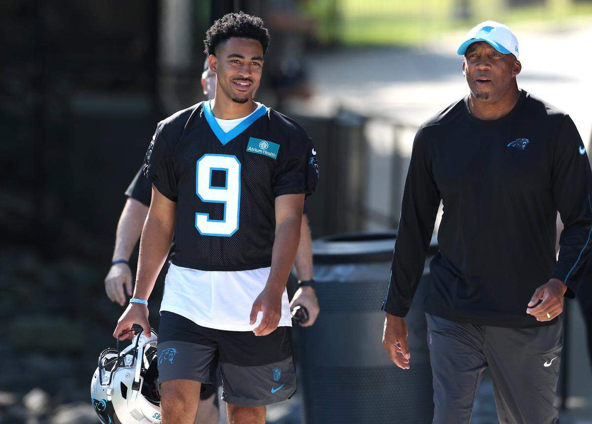 Carolina Panthers quarterback Bryce Young, left, walks to the team’s training camp practice on Wednesday, July 23, 2025.