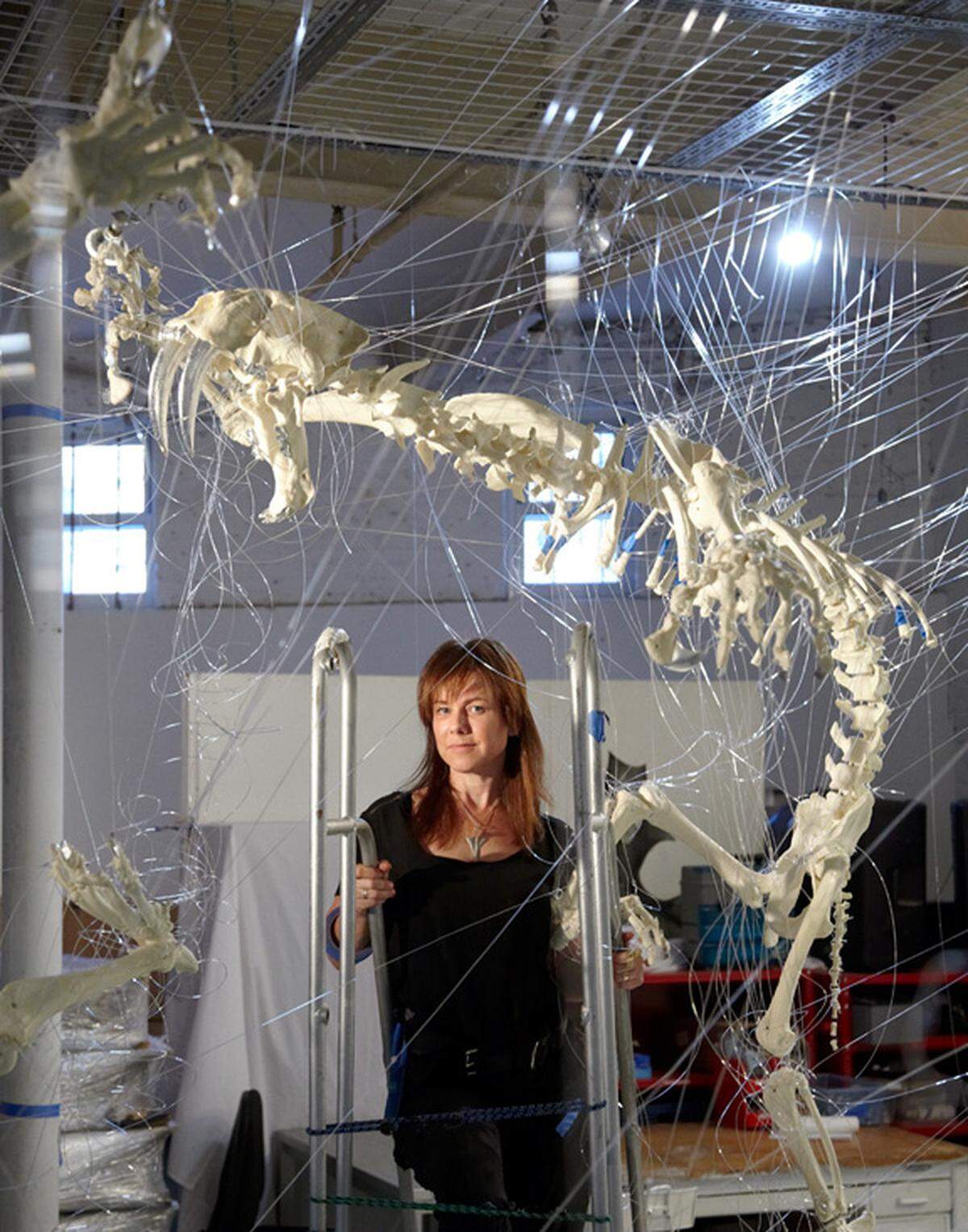 Brooklyn, New York, artist E.V. Day, with her art installation, “Cat Fight with Two Sabertoothed Skeletons.” Day also created “Daytona Vortex” out of an old Jimmie Johnson racing suit.