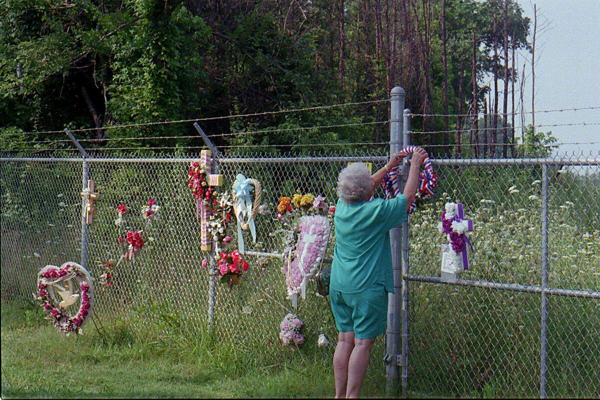 Martha Dunn places a handmade red, white and blue wreath on the fence at the site of the 1994 USAir crash. The plane crashed onto Dunn’s house but all of the home’s occupants were away at the time.