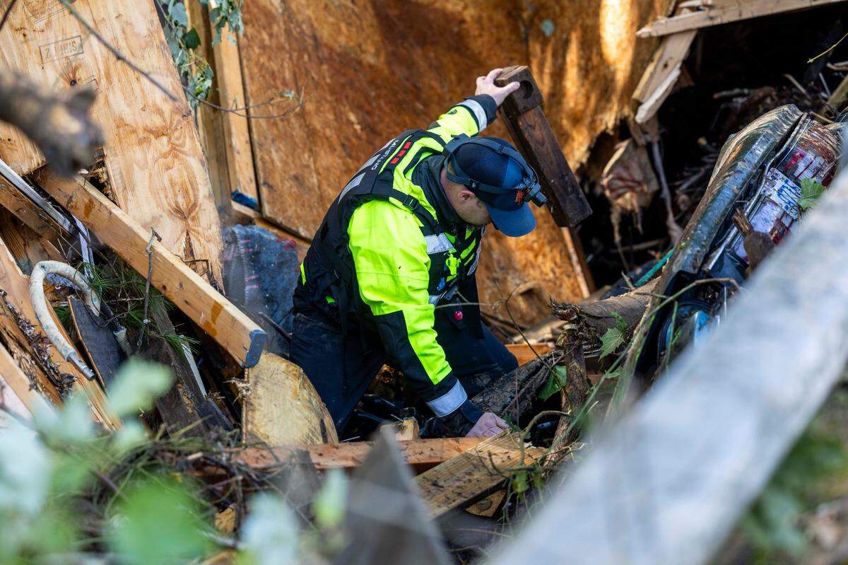 A Waynesville firefighter searches a car that was pinned by debris under a bridge on Richland Creek in Waynesville on Friday, Sept. 27, 2024 as the remnants of Hurricane Helene caused flooding, downed trees, and power outages in western North Carolina.
