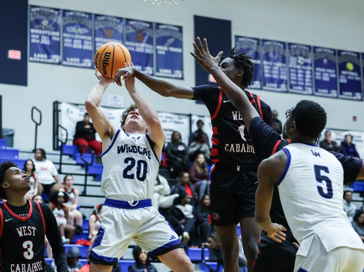 Lake Norman Wildcats Nick Arnold, left, shoots past West Cabarrus Wolverines Marcus Hurley at Lake Norman High School in Mooresville, N.C., on Tuesday, January 7, 2025.