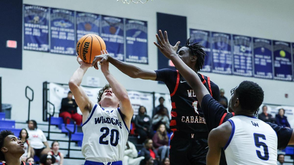 Lake Norman Wildcats Nick Arnold, left, shoots past West Cabarrus Wolverines Marcus Hurley at Lake Norman High School in Mooresville, N.C., on Tuesday, January 7, 2025.