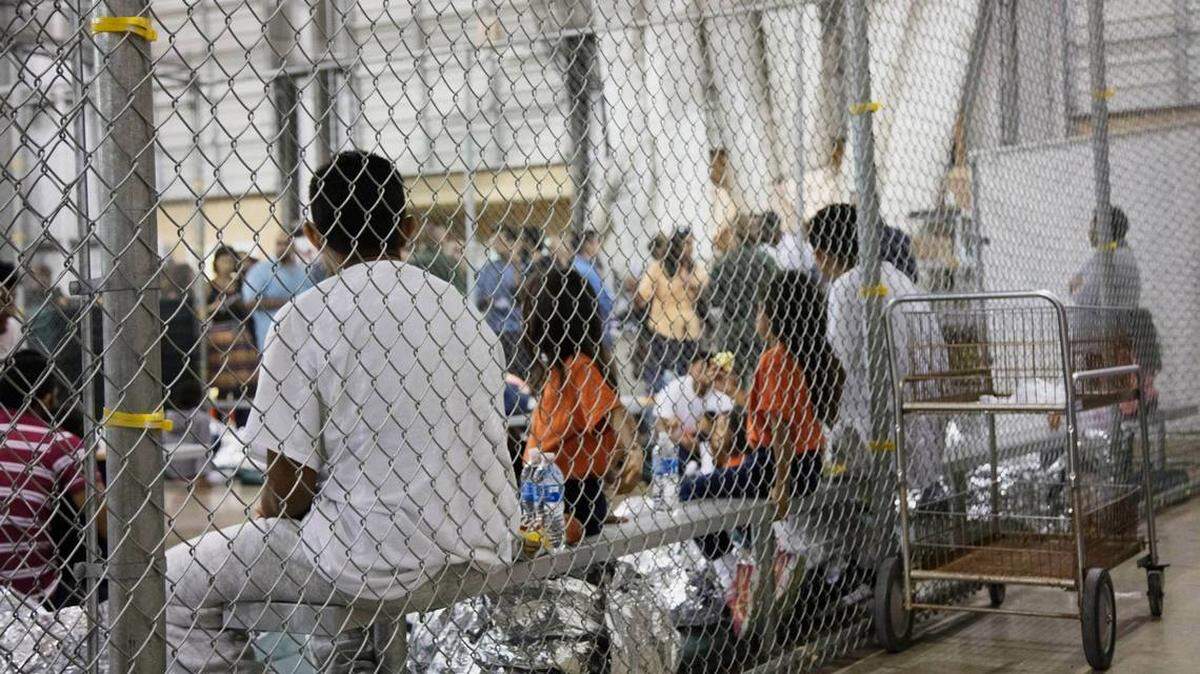 In this June 17, 2018, file photo provided by U.S. Customs and Border Protection, people who’ve been taken into custody related to cases of illegal entry into the United States, sit in one of the cages at a facility in McAllen, Texas. The U.S. Justice Department is in talks to pay hundreds of thousands of dollars to each child and parent who was separated under a Trump-era practice of splitting families at the border.